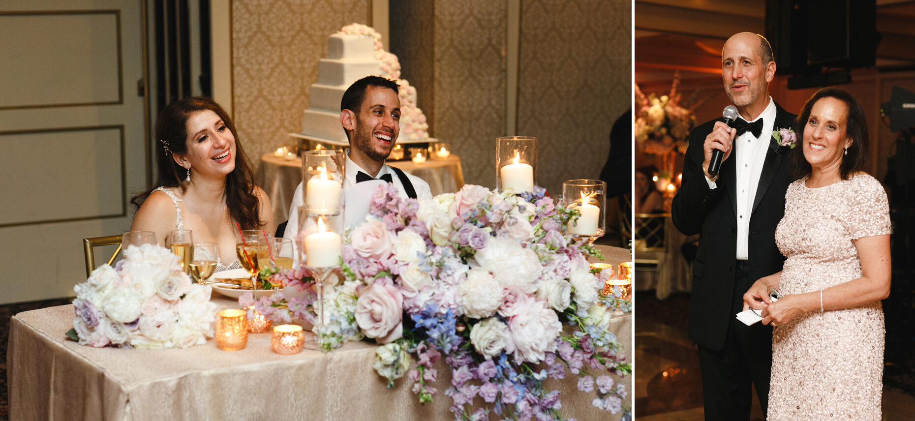 At a Glen Island Harbour Club Wedding, the couple sits at a flower-and-candle adorned table, listening to two guests speak into a microphone. A tiered cake graces the background, adding elegance to this charming reception.