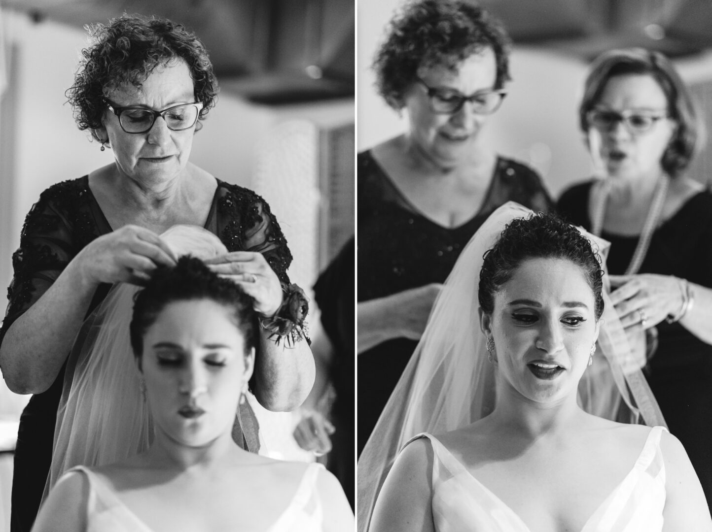 In the elegant setting of a Rockwood Park Carriage House wedding, two women carefully adjust a bride's veil. The bride sits serenely with her eyes closed as they focus intently on perfecting every detail. This timeless moment is beautifully captured in black and white.