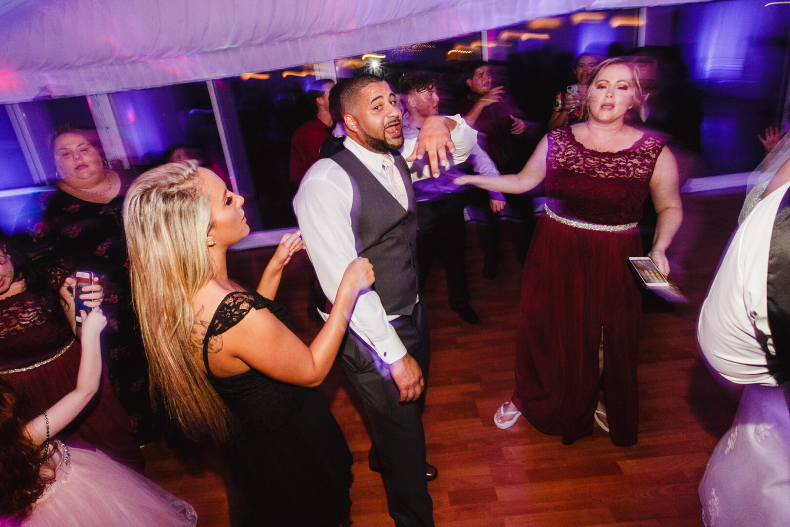 Guests danced and socialized under the colorful lighting, their reflections gliding across the polished wooden flooring at a Brandywine Manor House wedding.