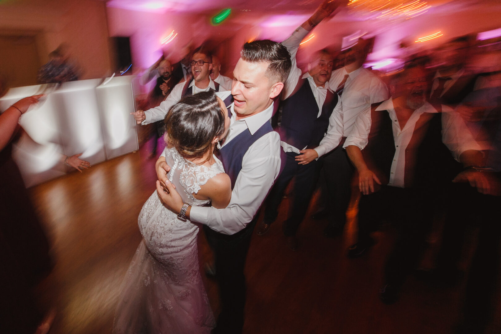 At the elegant Windsor Ballroom, a bride and groom dance energetically on the floor, surrounded by cheering guests.