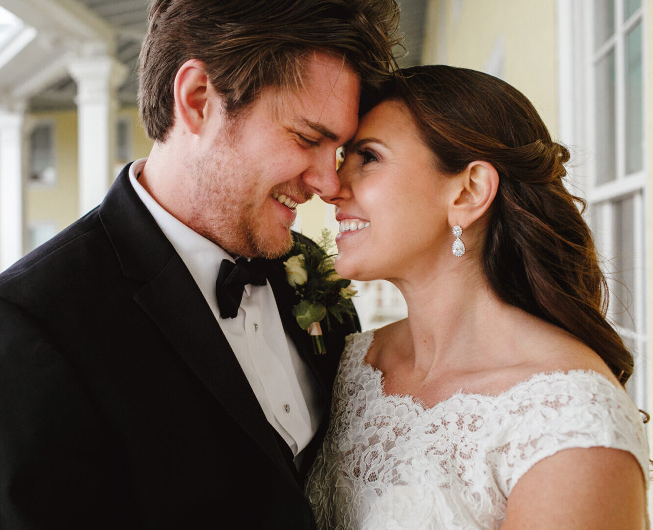 A man and woman are smiling, captured in a moment of pure joy at their Cape May wedding, where the coastal beauty adds an extra layer of magic to their unforgettable day.
