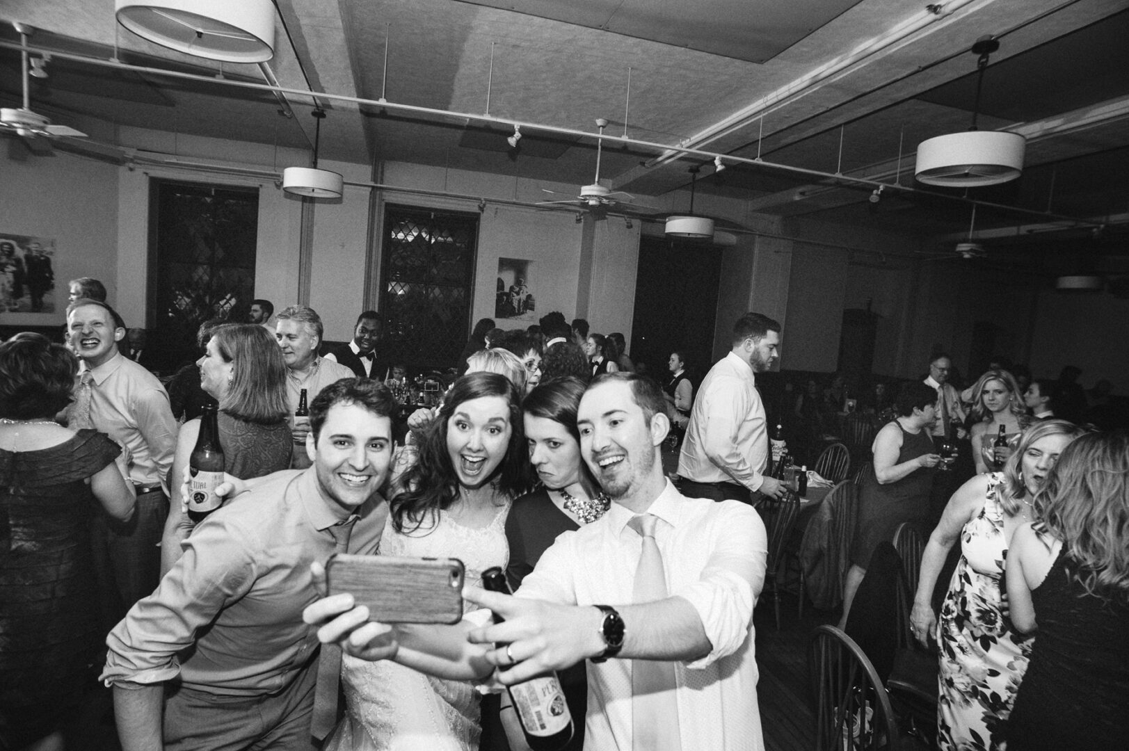At a lively Baldwin School event, four friends capture the moment with a selfie, surrounded by a bustling crowd.