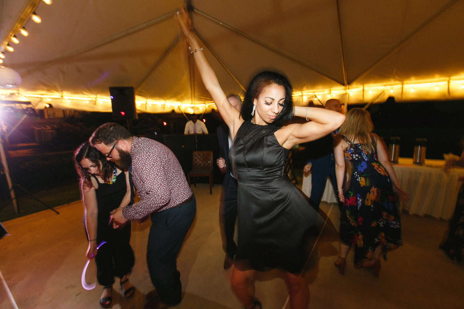 At a Corinthian Yacht Club of Philadelphia wedding, guests danced energetically under a tent adorned with twinkling string lights, creating an enchanting party atmosphere.