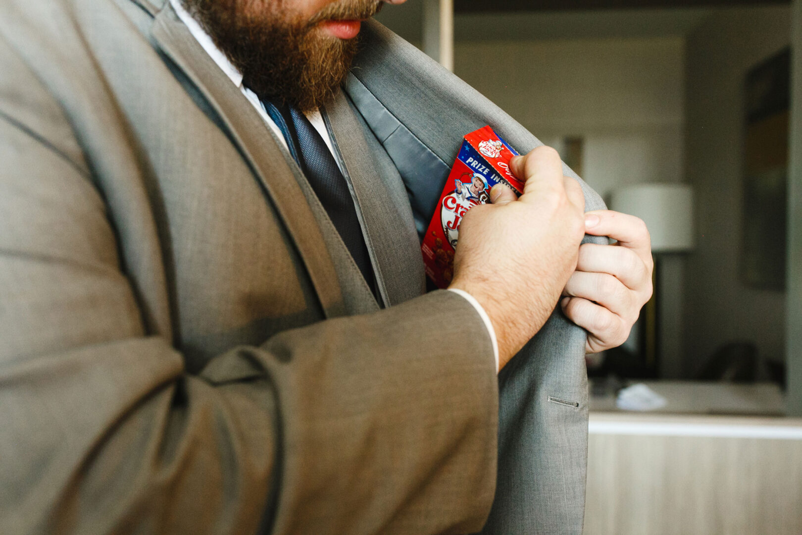 A man in a suit discreetly slides a pack of Chips Ahoy! cookies into his jacket's inner pocket, as if prepping for a sweet moment at the French Creek Golf Club wedding.