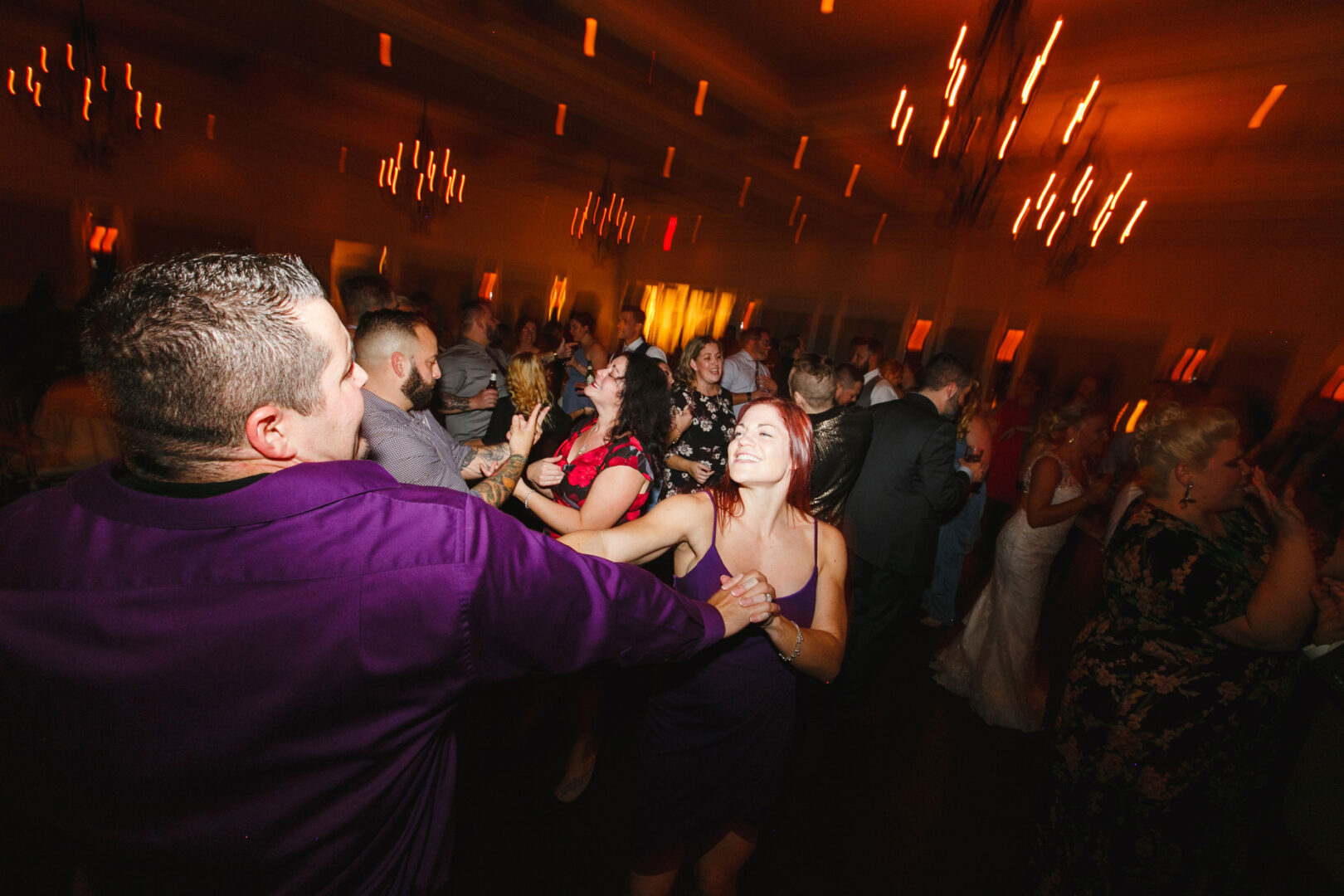 At a lively French Creek Golf Club wedding, guests danced energetically under warm lighting and elegant chandeliers, creating an unforgettable party atmosphere.