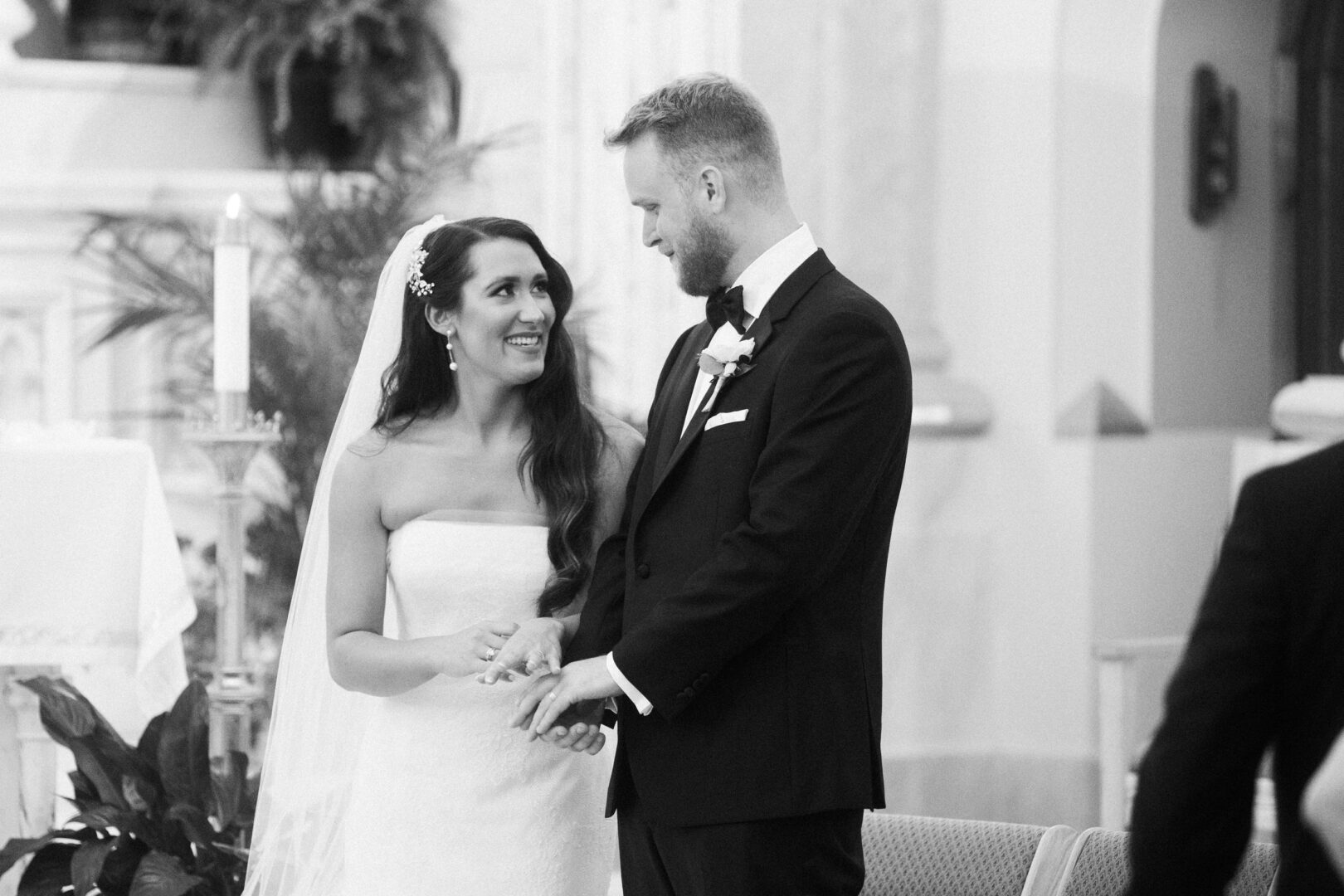 A bride and groom stand together, smiling and holding hands, amidst the enchanting setting of a Willow Creek Winery wedding.