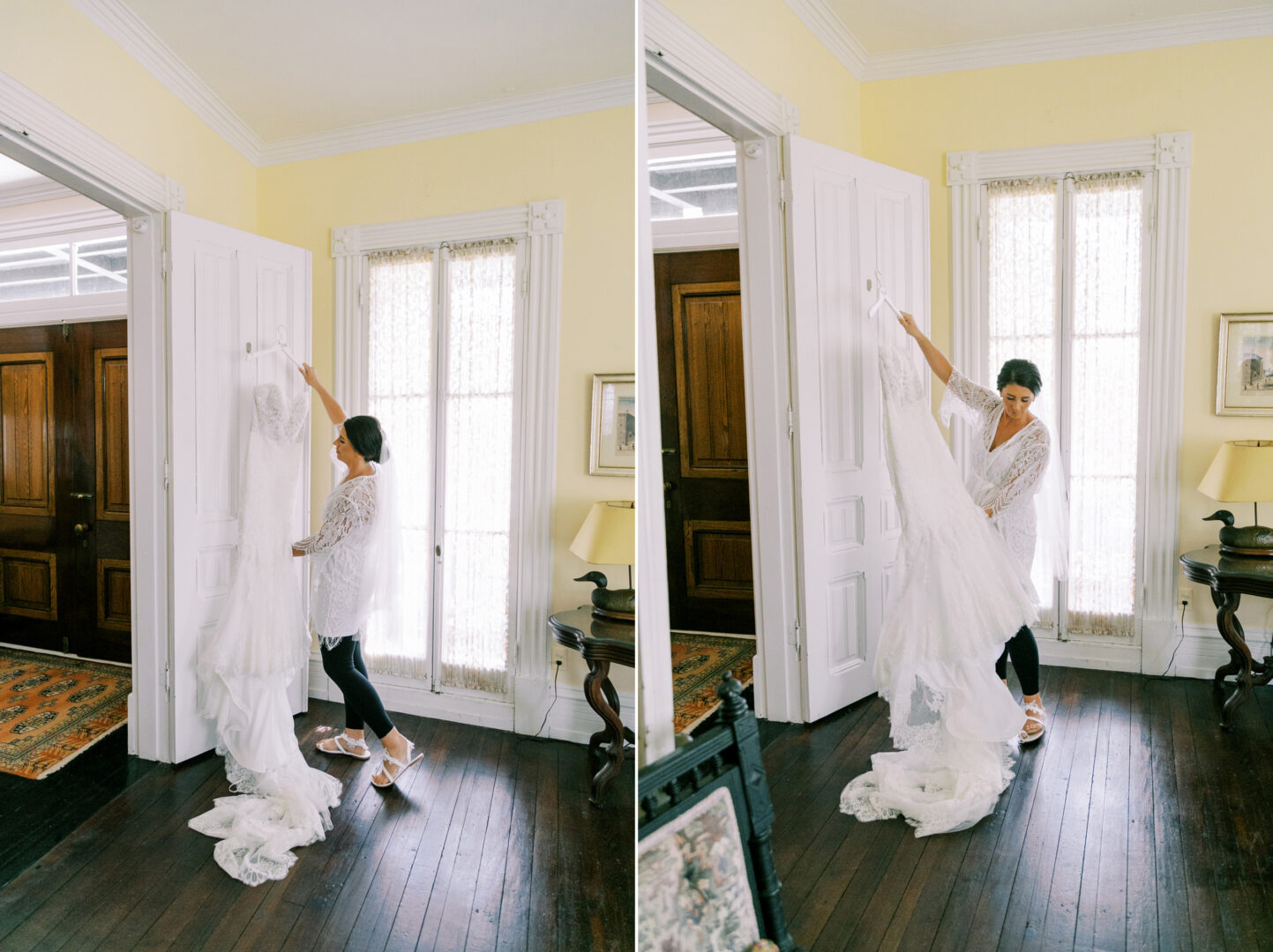 A person holds up a long, white dress in a room with wooden floors, tall windows, and light-colored walls.