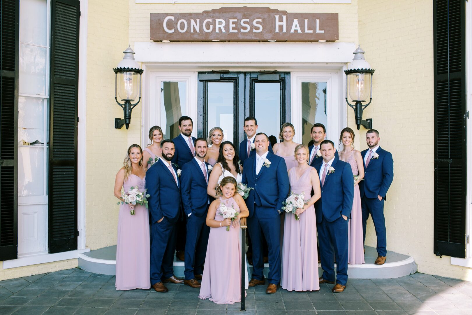 A wedding party pose for pictures in front of the Congress Hall sign.