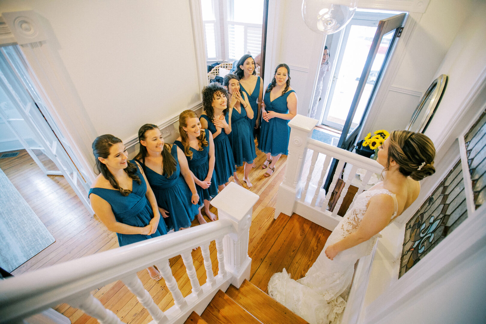 Bridesmaids react to seeing the bride in her dress for the first time.