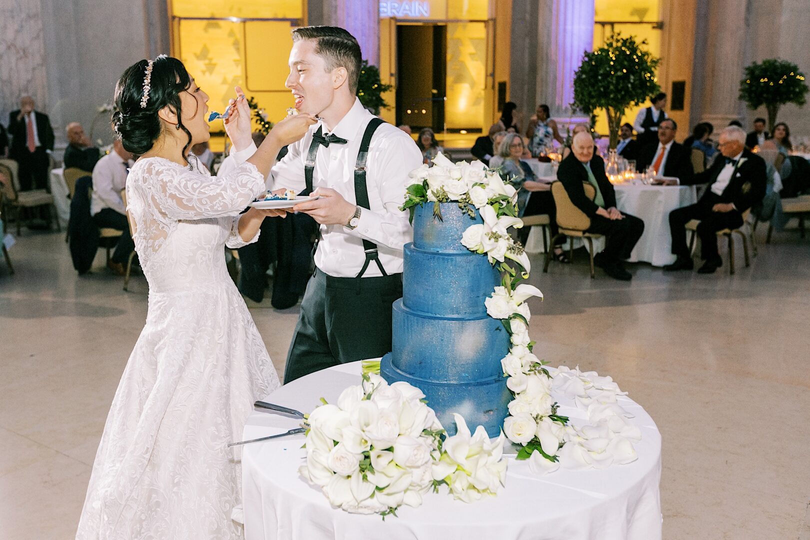 Bride and Groom eating their cake at their classic wedding at the Franklin Institute