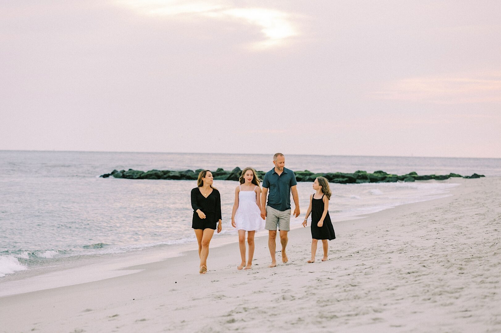 Family walking along the beach in New Jersey during a portrait session