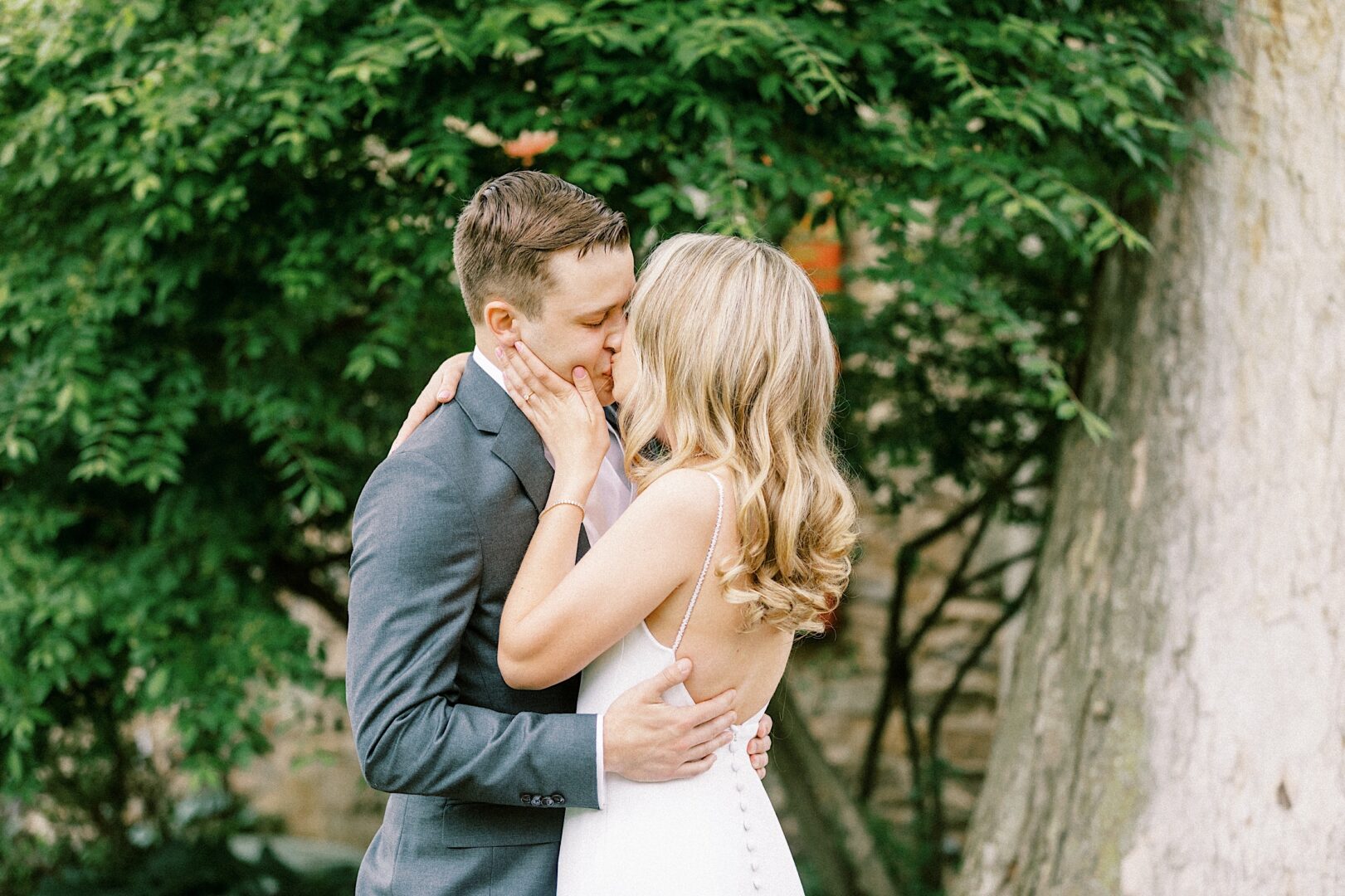 Bride and groom kiss during a first look on a bright spring wedding day in Ambler