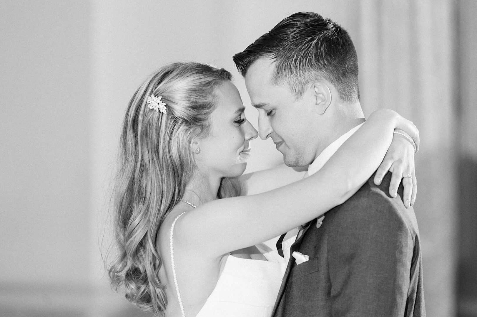 Bride and groom dancing close during their first dance at a spring country club wedding reception