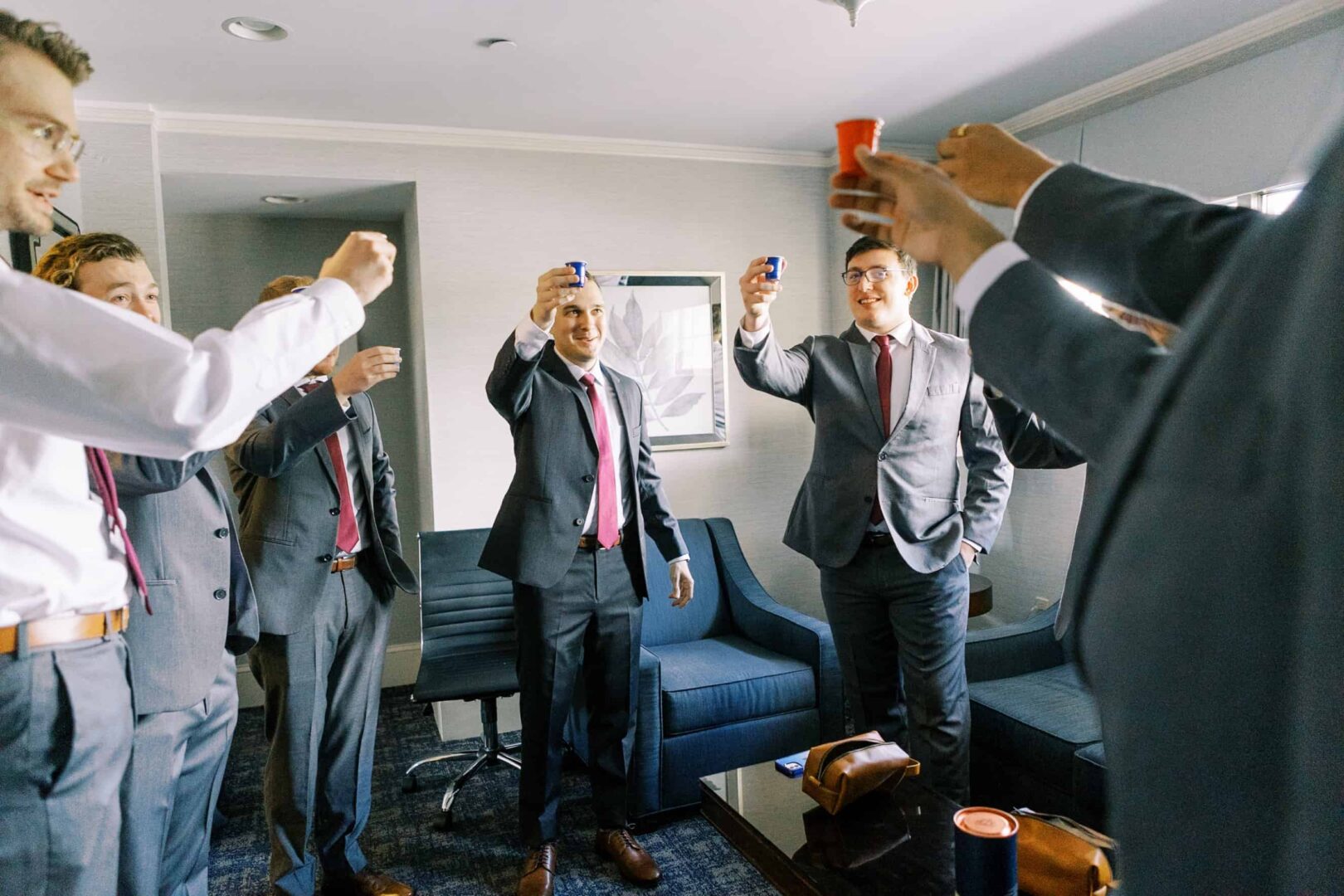 Groomsmen doing a shot of whiskey at the start of the wedding day.