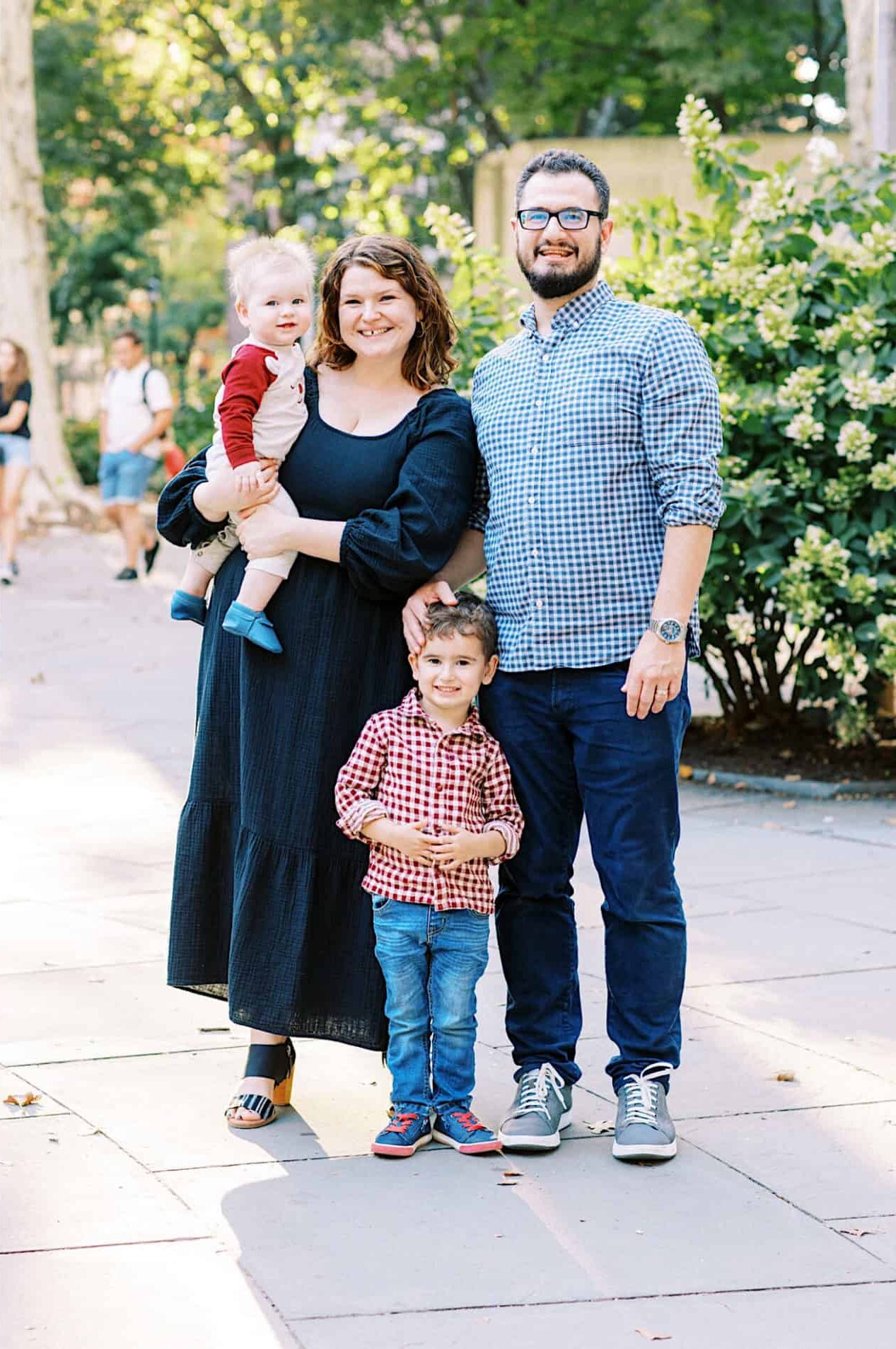 Left: Close-up of an adult and child holding hands. Right: A family of four poses outdoors on a sidewalk surrounded by greenery, capturing family photos at Washington Square in Philadelphia.