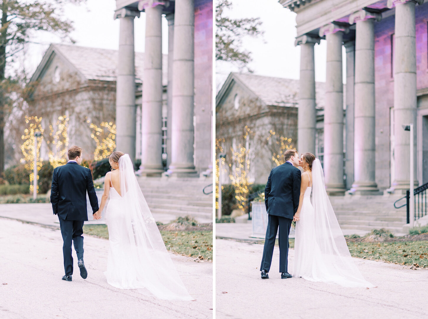 A newlywed couple, the bride in a white dress and veil and the groom in a dark suit, share a kiss outside the ballroom at Ellis Preserve. The columned building is elegantly adorned with string lights, creating a magical backdrop for their special moment.