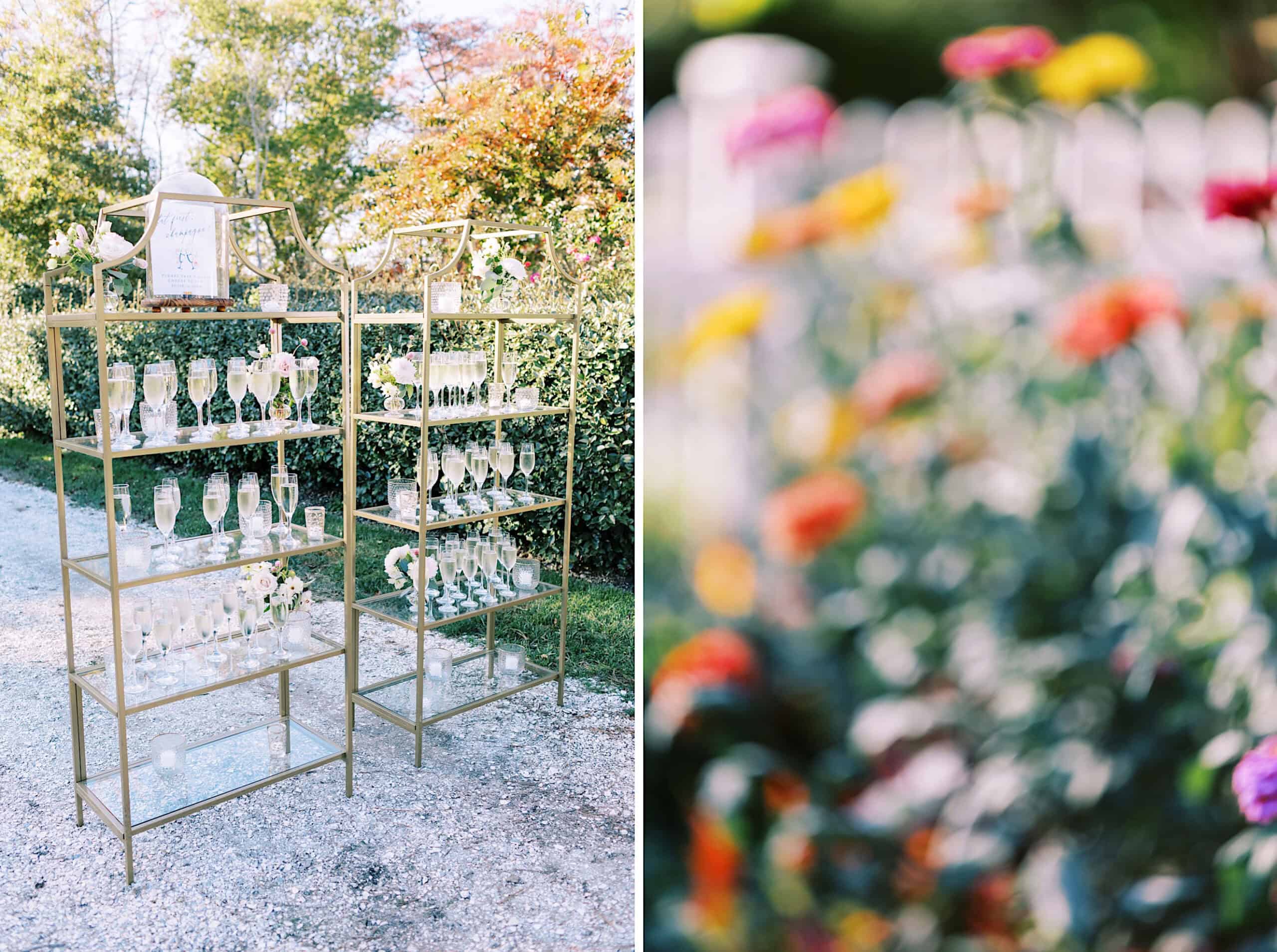 A gold shelving unit displays rows of champagne glasses filled with drinks outdoors at a Beach Plum Farm Wedding; colorful blurred flowers are visible in the foreground on the right.