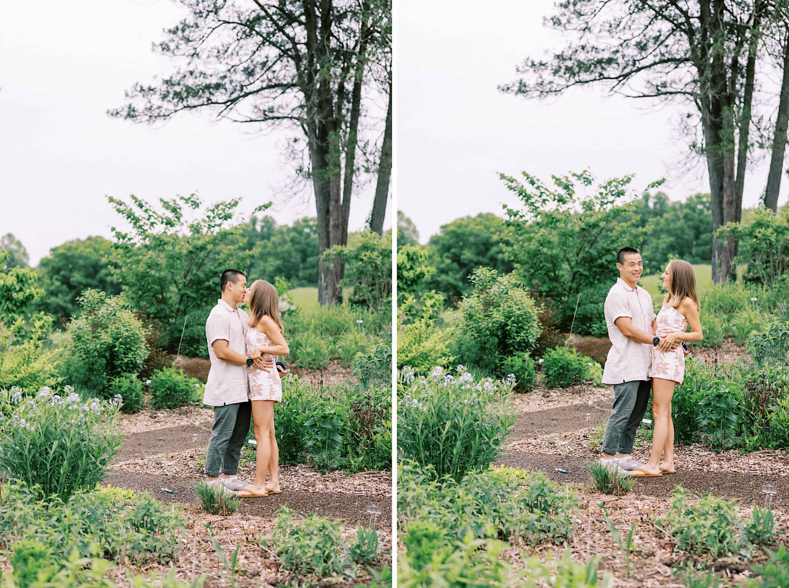 A couple stands together outdoors on a dirt path surrounded by greenery during their Engagement Photo Session at Twinning Valley Park; in one image they embrace, in the other they hold hands and smile at each other.