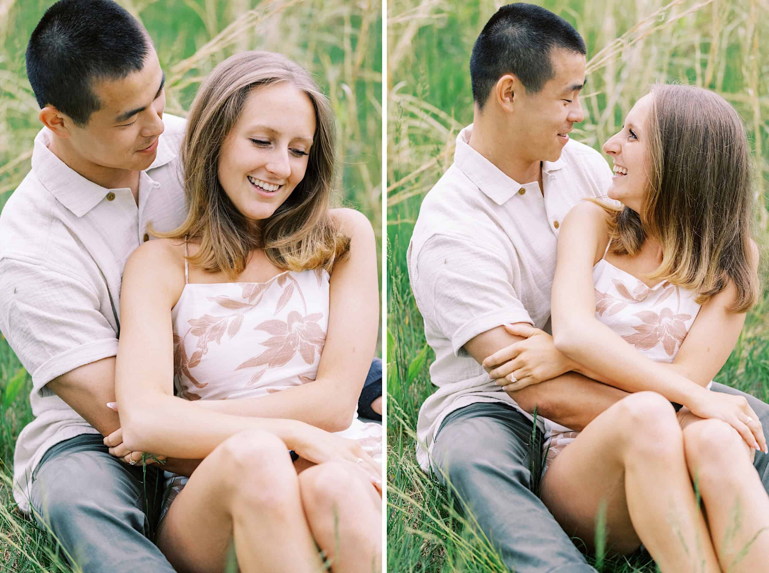 A couple sits together on the grass, embracing and smiling at each other during an engagement photo session at Twinning Valley Park, surrounded by a beautiful natural outdoor setting.