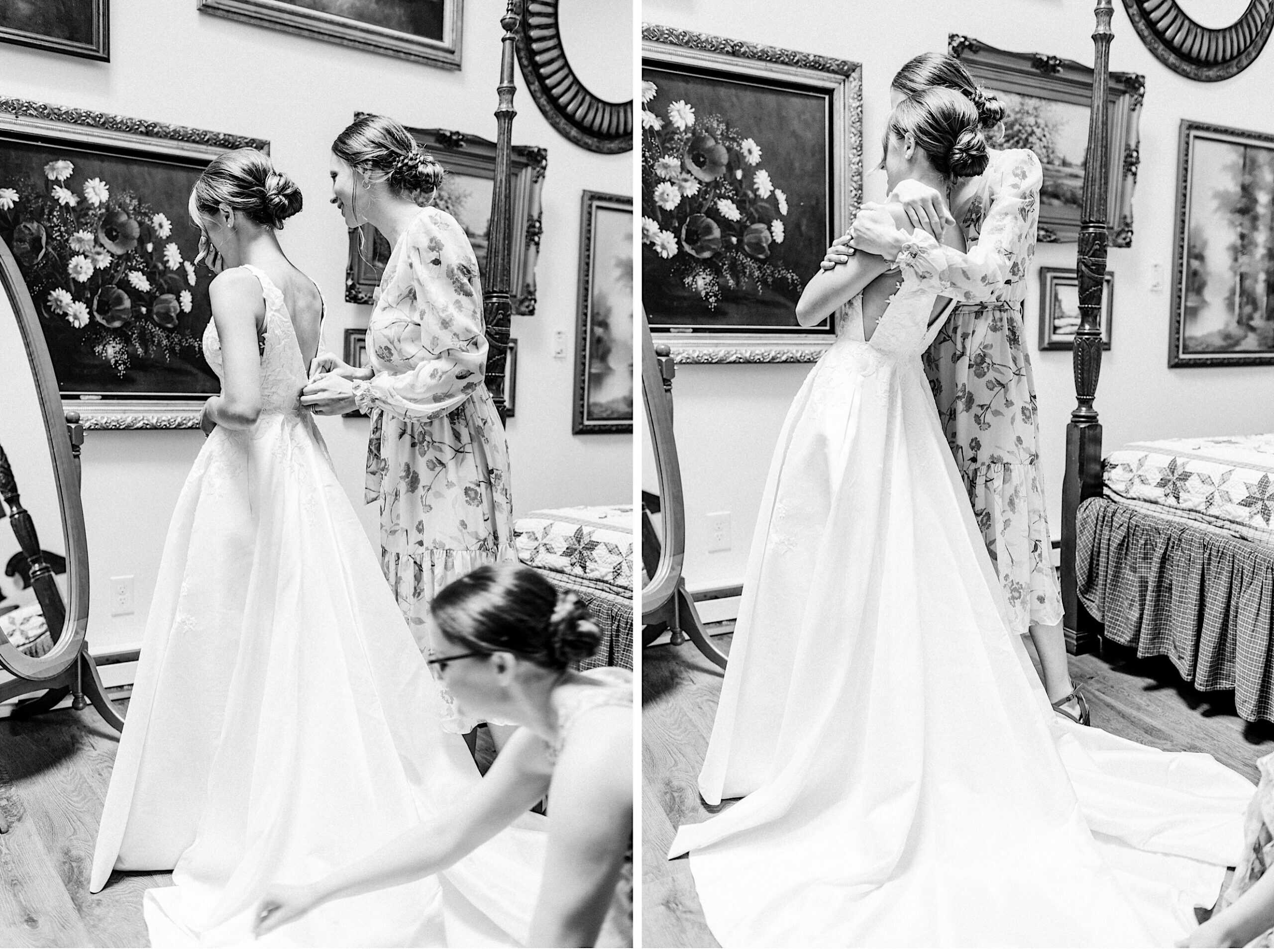 Two women help a bride adjust and fasten her wedding dress in a room decorated with floral paintings and a four-poster bed, capturing the excitement of a Summer Wedding at The High Point.