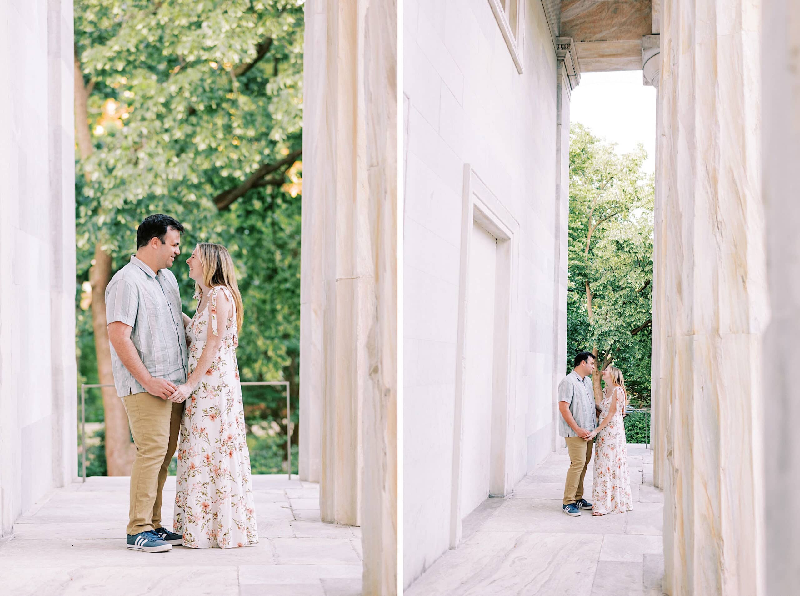 A man and woman stand facing each other, holding hands, in a marble corridor with trees visible in the background—perfect setting for Old City Philadelphia engagement photos.