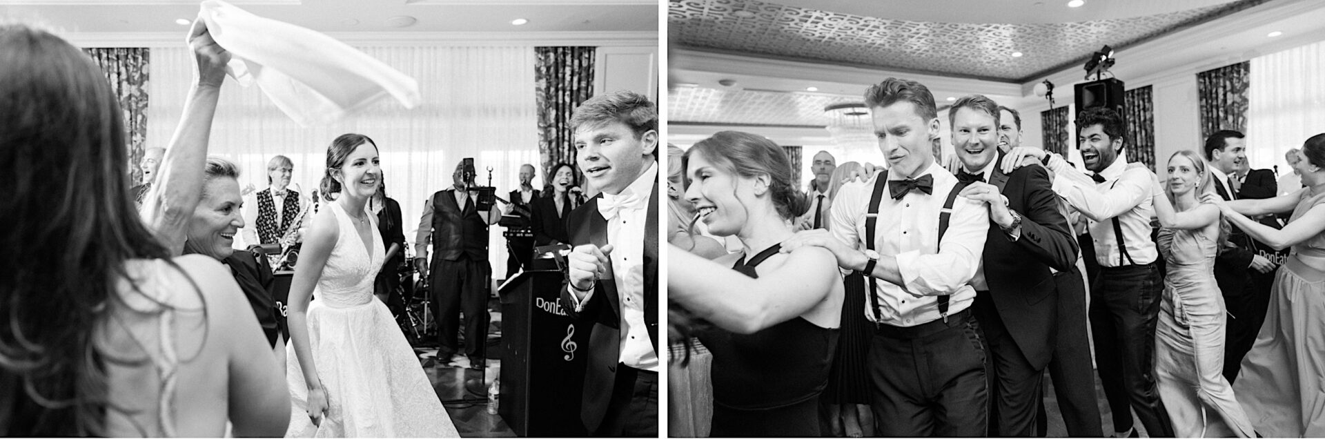 Black and white photo of a lively Overbrook Golf Club Wedding reception with people dancing. The bride and groom from Villanova are on the left, smiling and dancing, while on the right, guests form a conga line at this charming Philadelphia celebration.