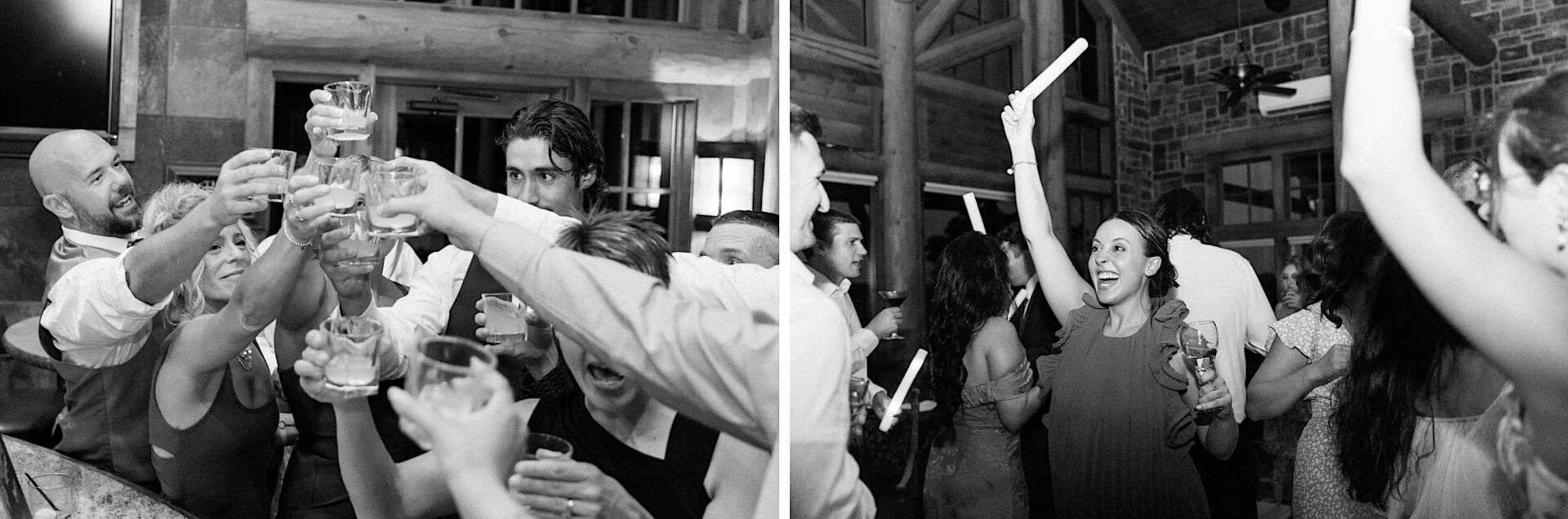 Black and white photo of people at a lively wedding party. On the left, guests raise glasses in a toast. On the right, a woman enthusiastically holds up a glow stick while others dance, capturing the joyous atmosphere at The Ridge at Back Brook Country Club.