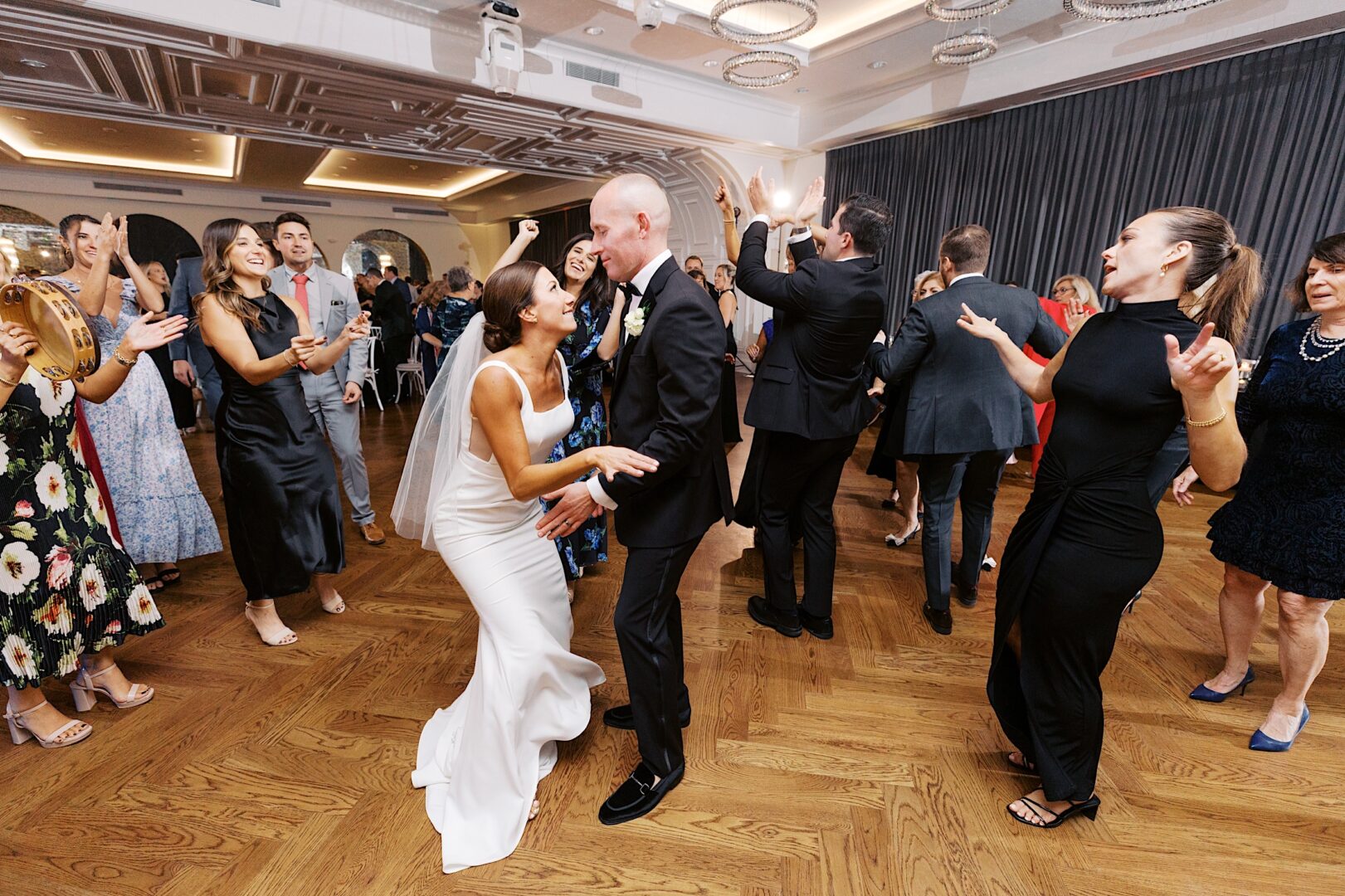 The bride and groom dance gracefully together at The Tilling House wedding, surrounded by guests in formal attire at the elegant reception.