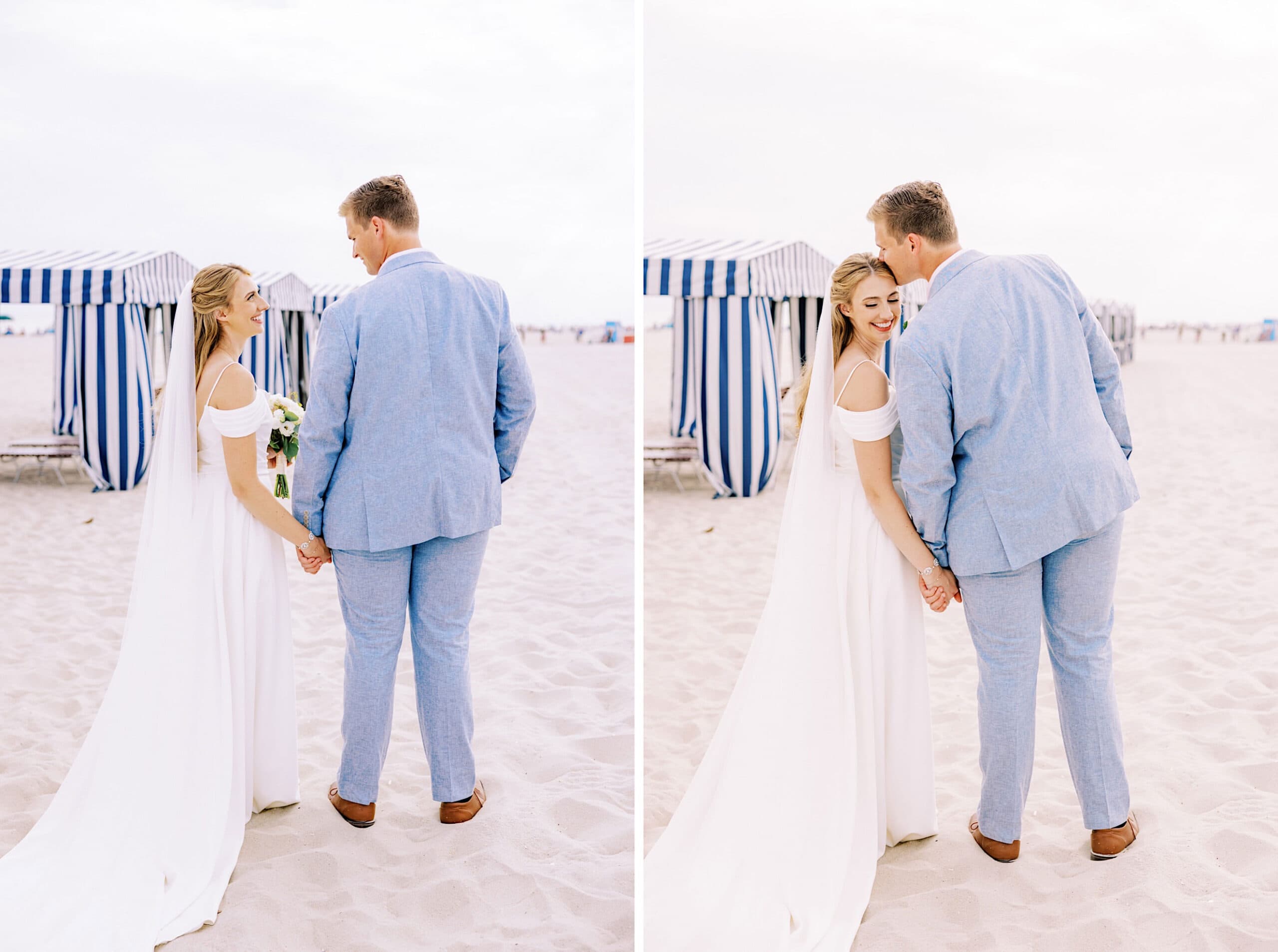 A bride and groom in wedding attire stand on a sandy beach at their Montreal Beach Resort Wedding, holding hands with striped cabanas in the background.