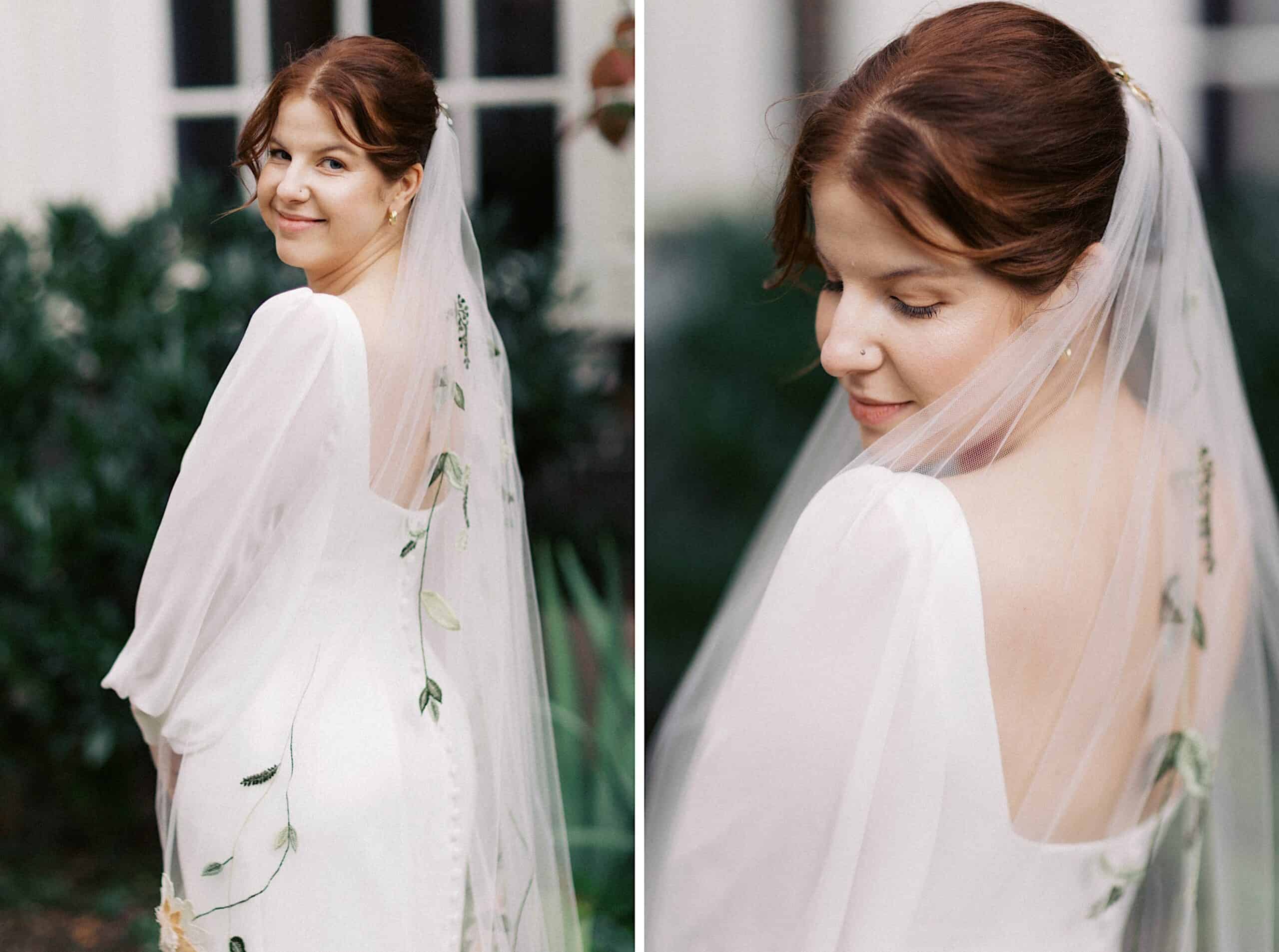 A bride with a floral-embroidered veil and white dress stands outdoors, facing slightly away and smiling softly at the camera.