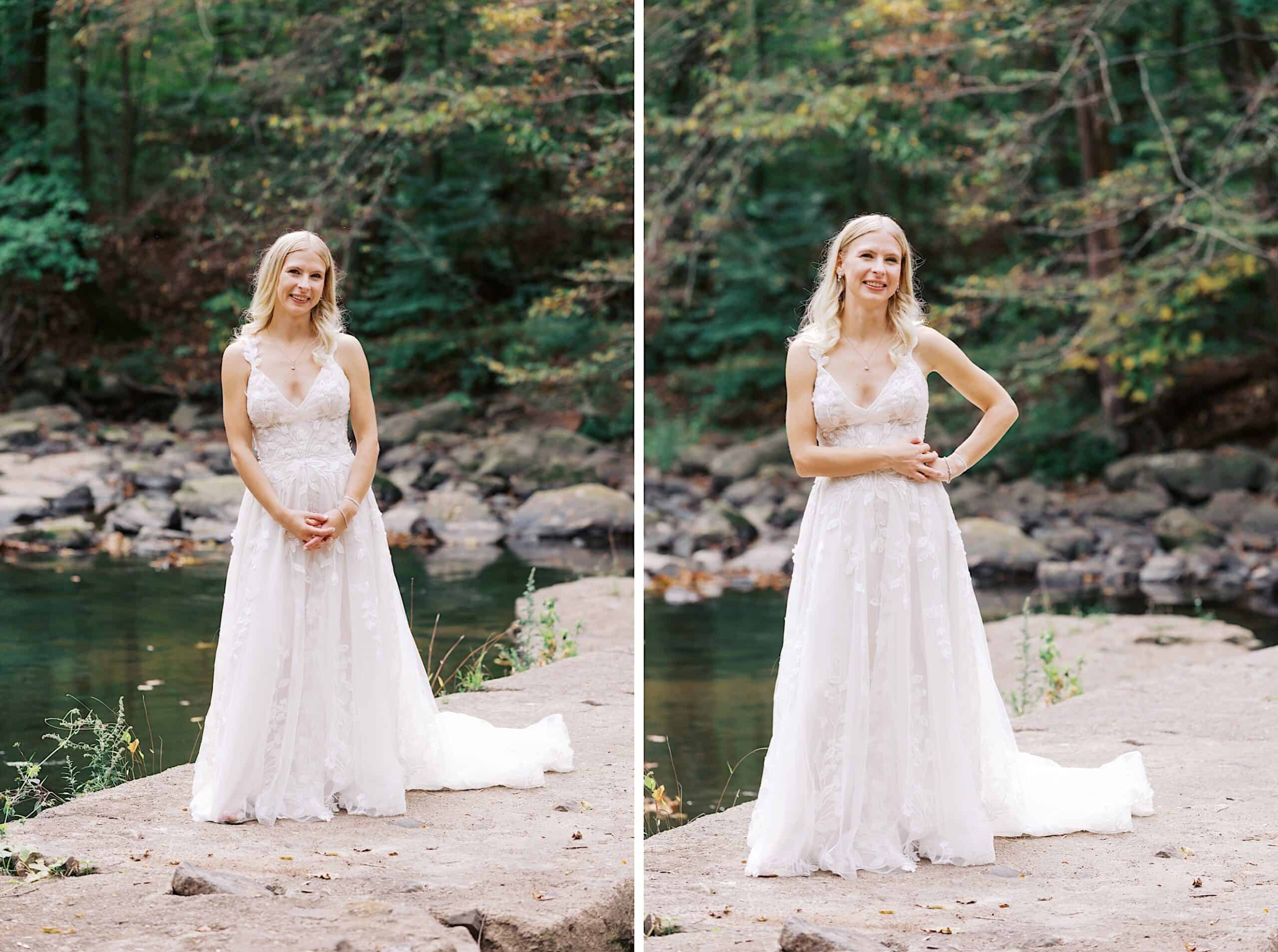 A woman in a white wedding dress stands outdoors on a stone path near a river, surrounded by green trees and rocks—a beautiful wedding at Vincent Forge Mansion.