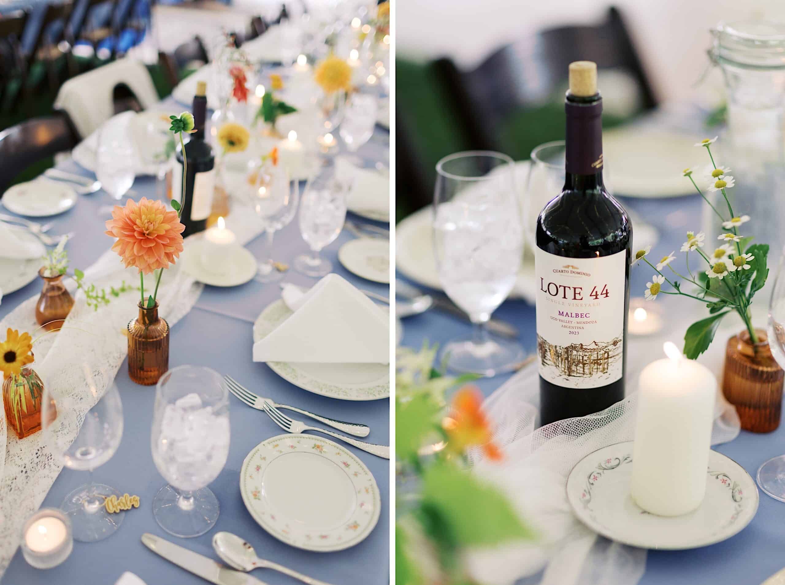 A table set for a meal at a beautiful wedding at Vincent Forge Mansion, adorned with floral centerpieces, wine bottles, candles, plates, utensils, and glasses on a light blue tablecloth.