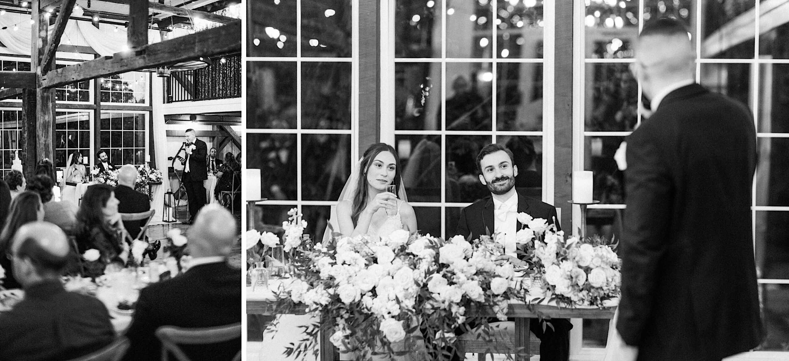 A bride and groom sit at a flower-adorned table, listening to a speech at their beautiful Lochwood Manor wedding, with guests seated around them in a decorated venue.