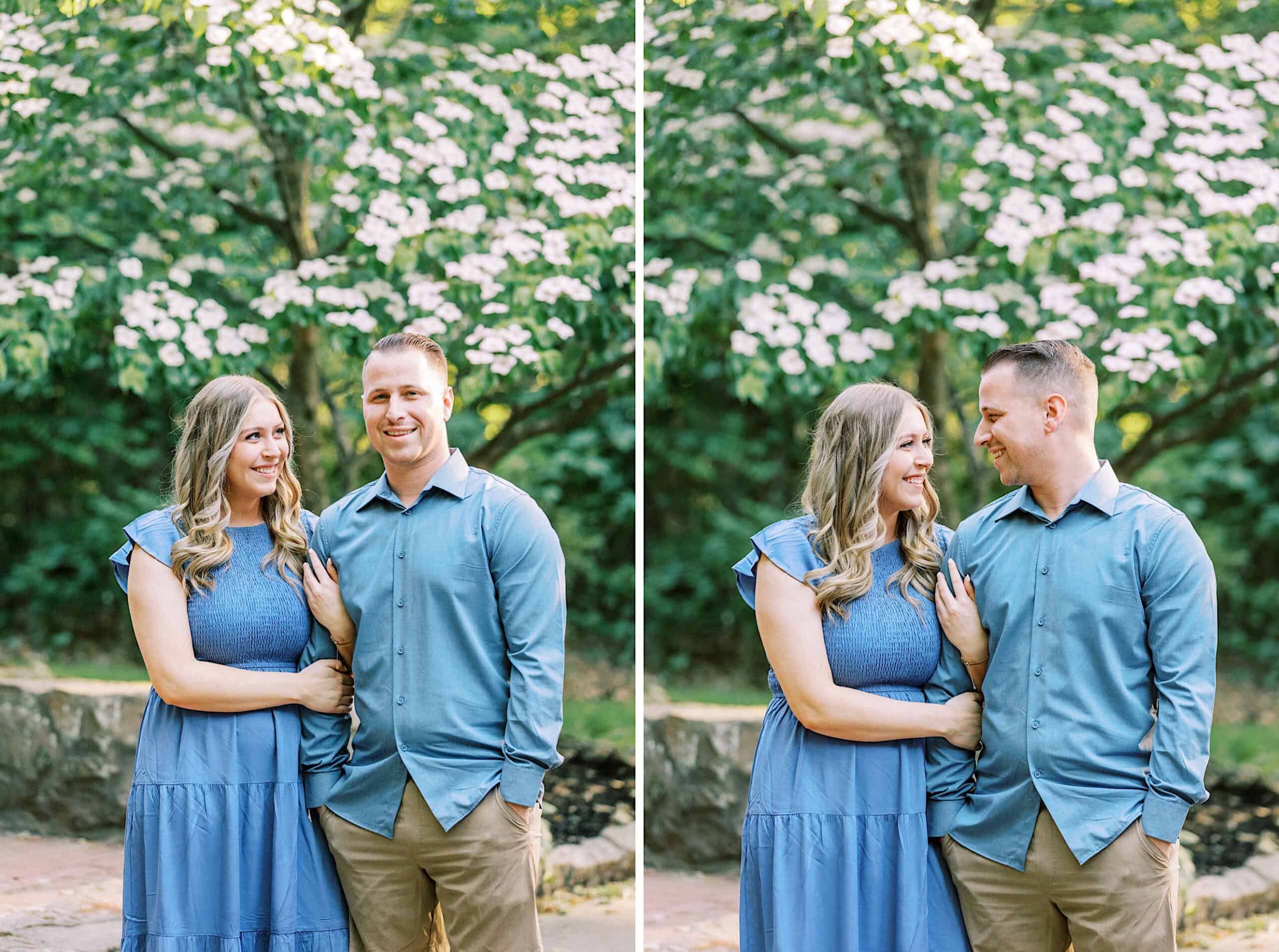 A man and woman stand side by side outdoors, both in blue outfits, smiling at each other beneath a flowering tree—perfect inspiration for Spring Family Photos in Bucks County.