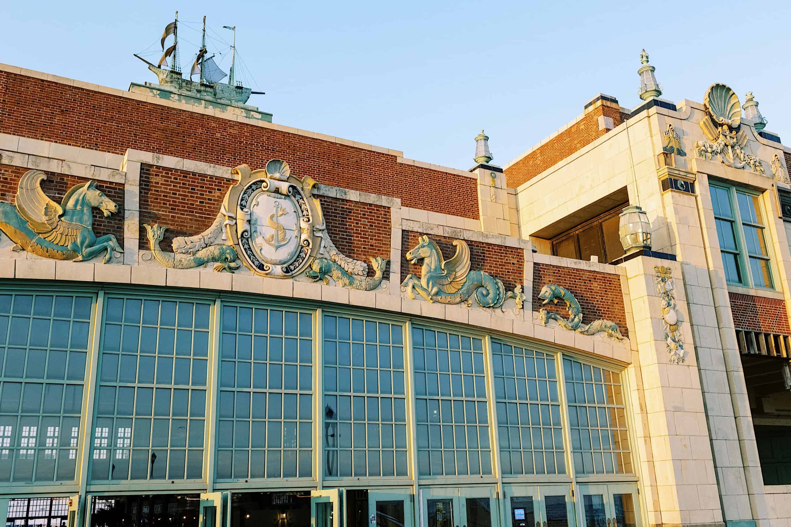 Ornate building facade with large green-framed windows, decorative sea creature reliefs, and nautical motifs under a clear sky—an iconic spot for unique Asbury Park Engagement Photos.