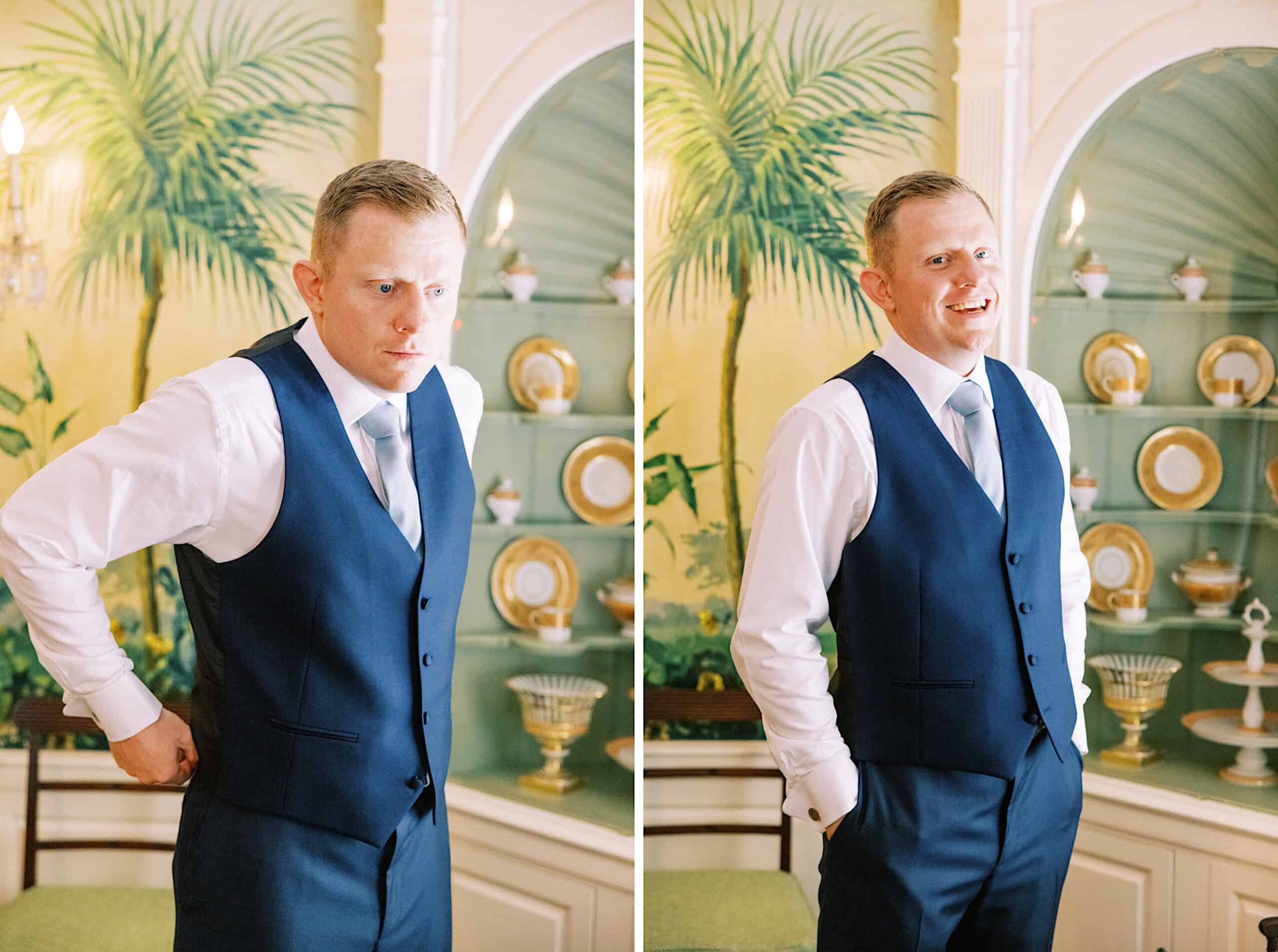 A man in a blue vest and tie stands indoors at a Summer Wedding at Appleford Estate, posing in front of a decorative wall with shelves of plates—first looking serious, then smiling.
