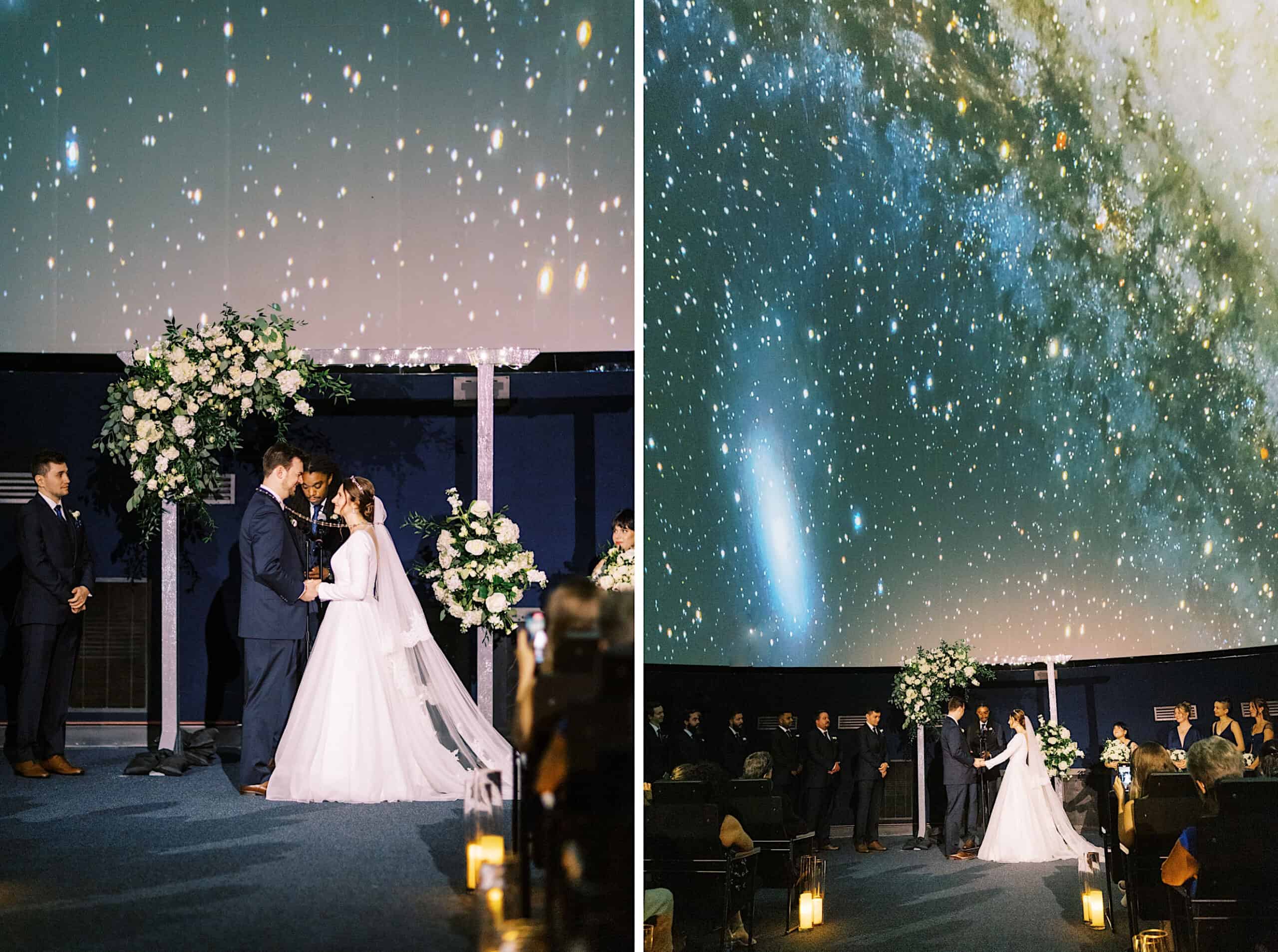 A couple stands under a floral arch, exchanging vows in a Franklin Institute wedding inside the planetarium, with a star-filled galaxy projection above as guests look on from their seats.
