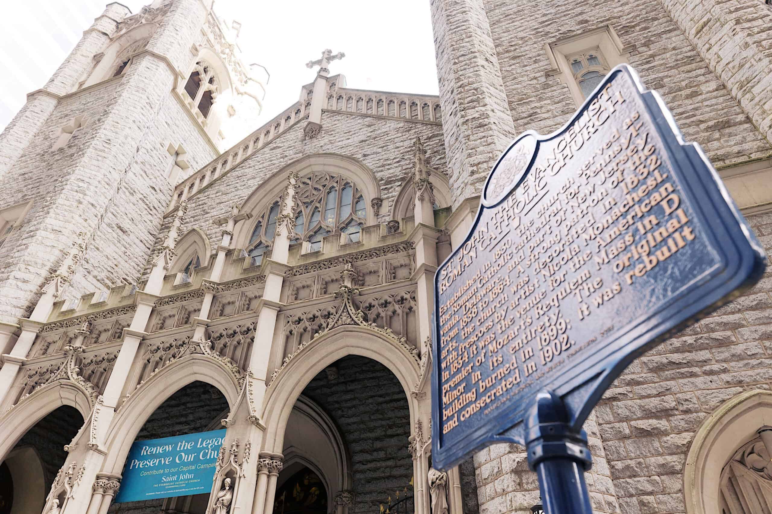 Stone church with gothic arches and ornate facade; in the foreground, a historical marker sign highlights the building’s legacy—an ideal setting reminiscent of a Classic Wedding at Ballroom at the Ben.