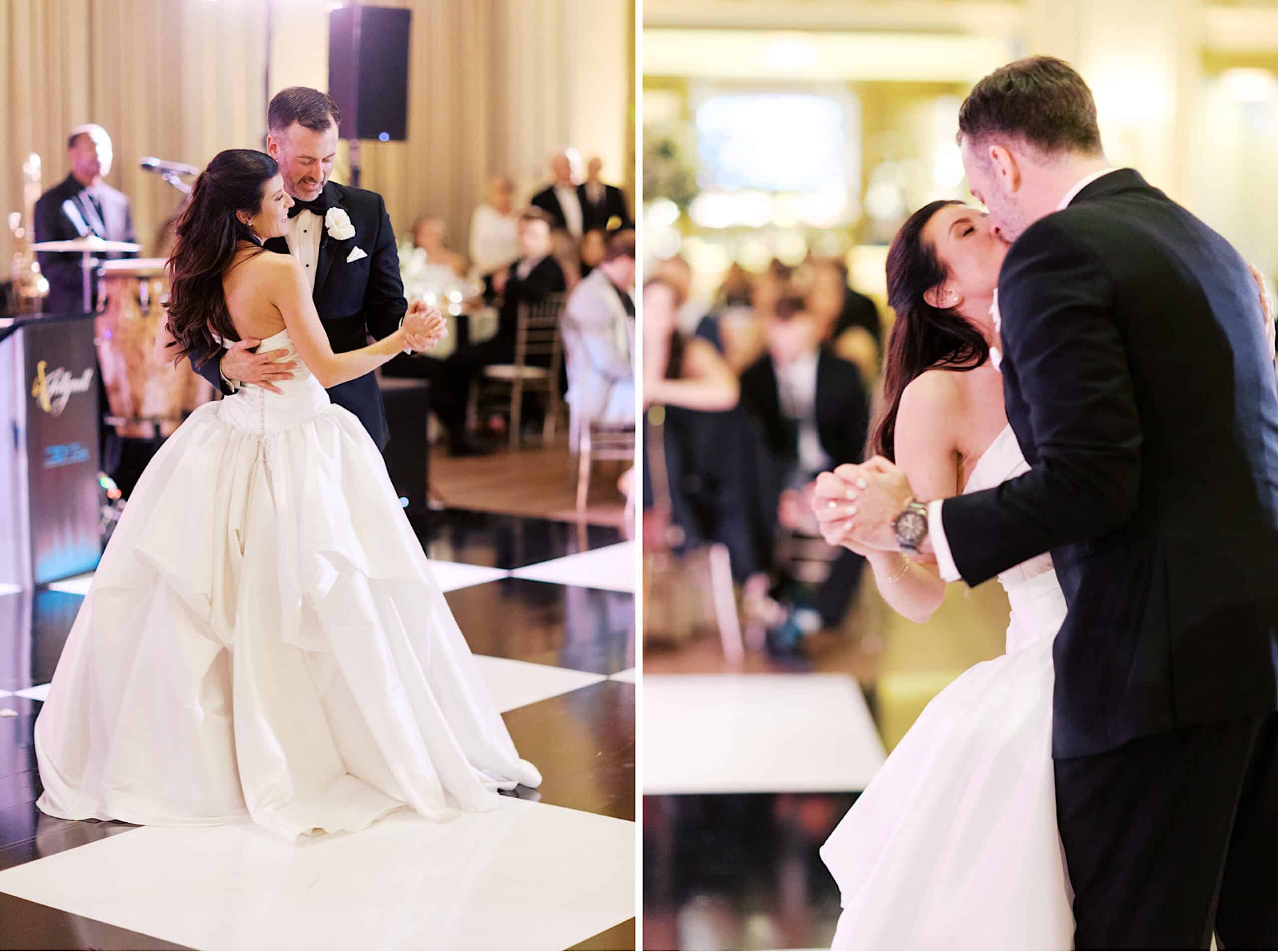 A bride and groom dance together at their Classic Wedding at Ballroom at the Ben, holding hands and smiling, with guests seated in the background.