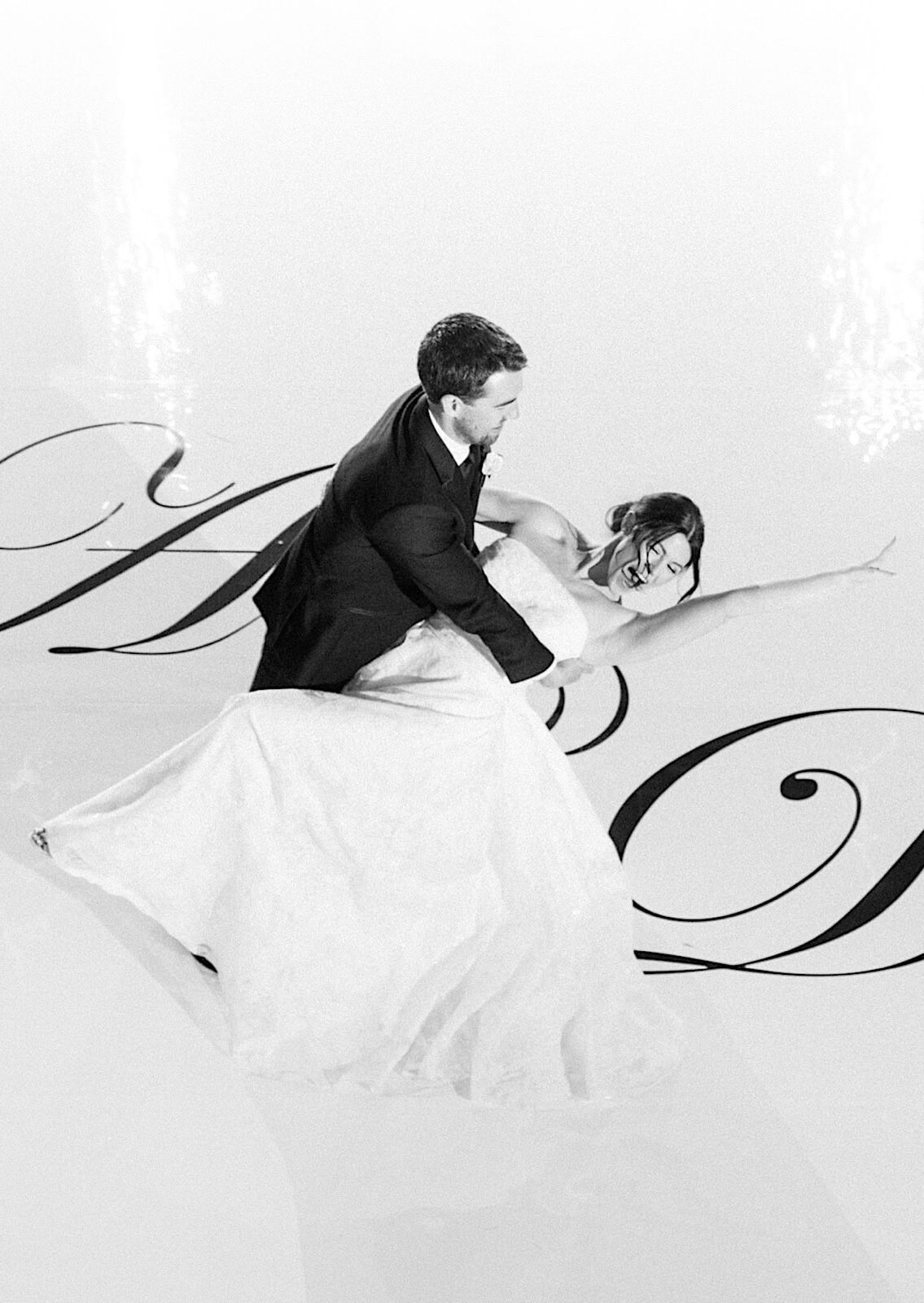 A bride and groom dance on a white floor with large decorative script letters at their The Ivy at Ellis Preserve spring wedding.