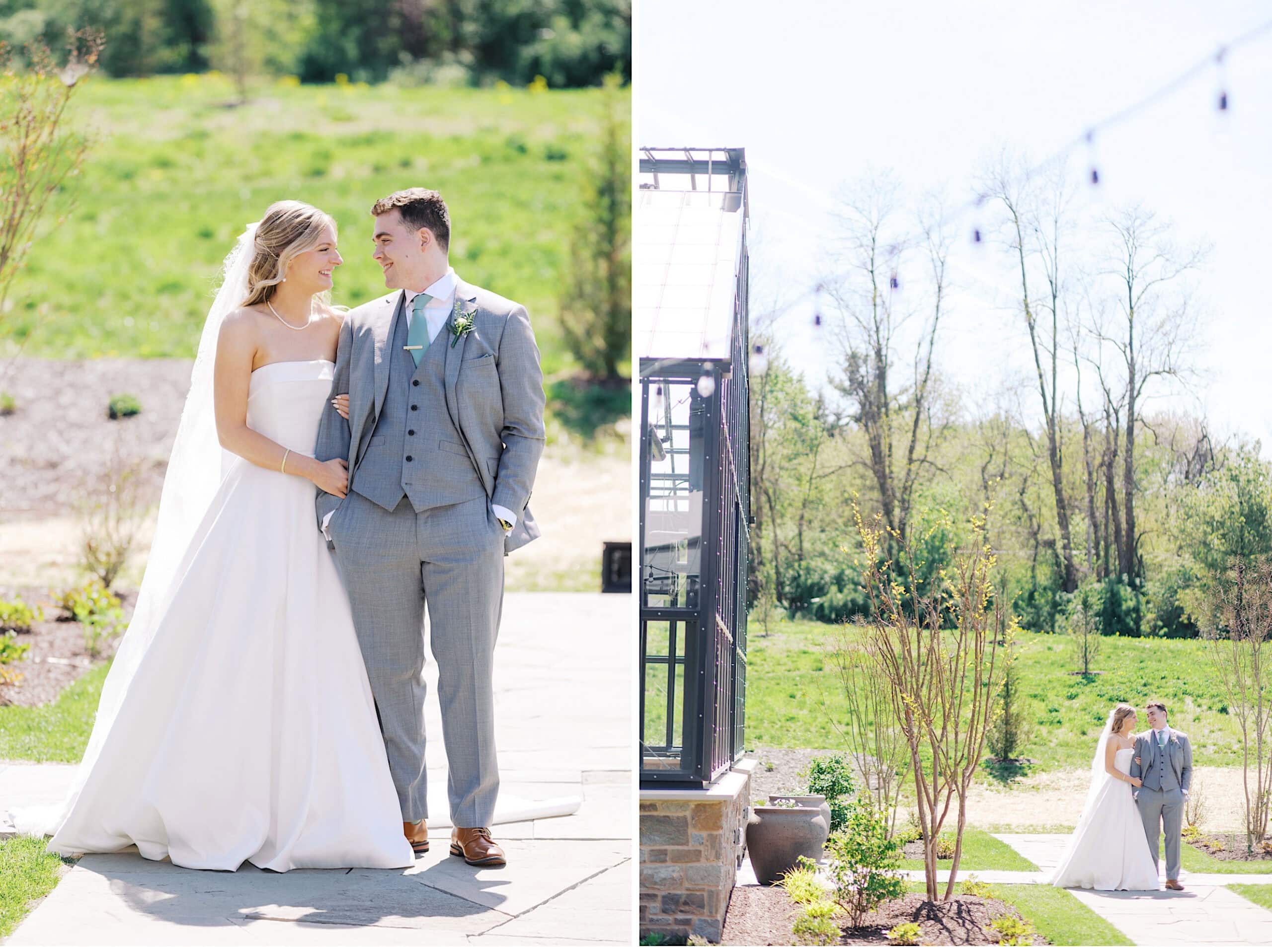 A bride in a white dress and a groom in a gray suit stand outdoors on a sunny day, smiling at each other during their Westwynd Gardens Spring Wedding.
